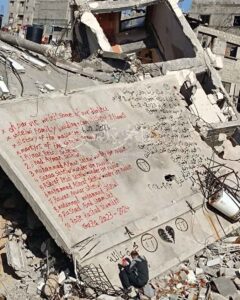 Un palestino escribe los nombres de sus familiares atrapados bajo las ruinas de Gaza